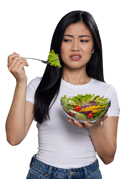 A woman warily eating a forkful of salad.