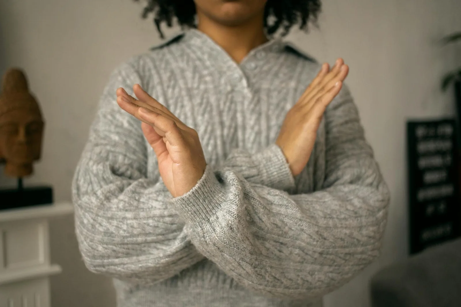 A person making a crossed-arms refusal gesture