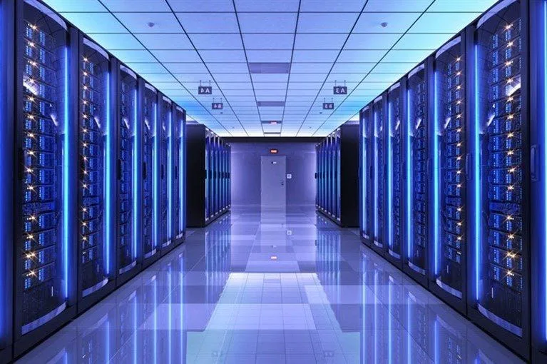 Rows of server racks lit blue down a long data-centre aisle