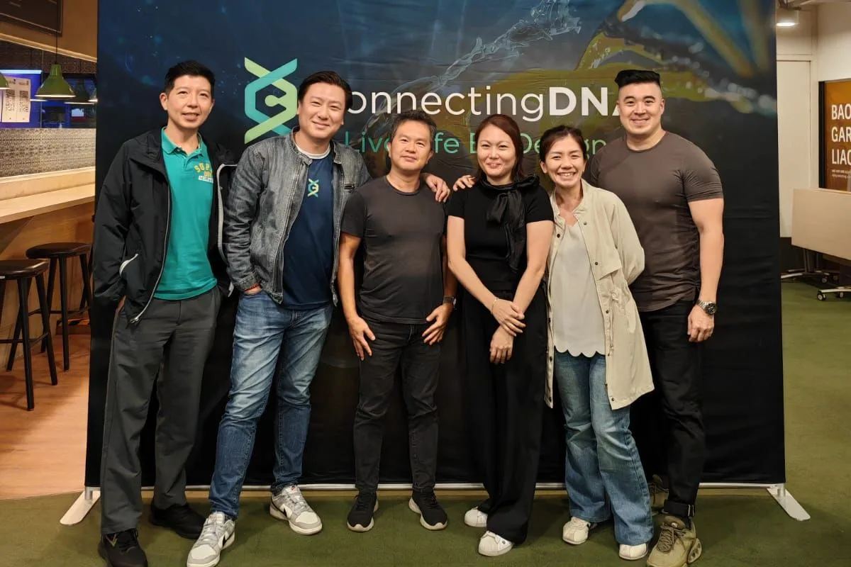 Six of the ConnectingDNA team standing together in front of a ConnectingDNA backdrop